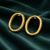 Anti-Tarnish Gold Plated Oval Earrings by House of Viya on dark green fabric background
