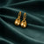 Anti-Tarnish Gold Plated Hanging Bags Earrings by House of Viya on dark green fabric background