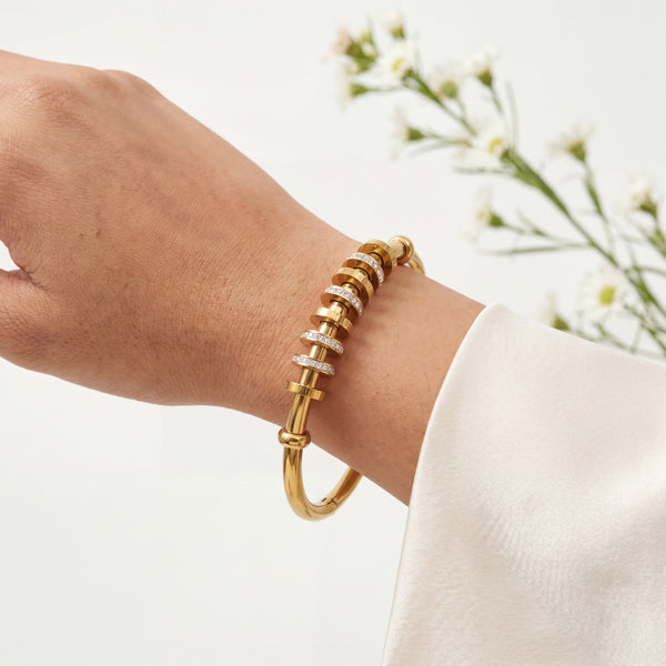 Gold bracelet on a wrist with a blurred background