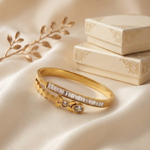 Gold bracelet with diamond accents on a beige fabric background