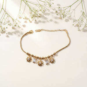 Gold Plated Snake Chain Bracelet with Starburst Floral Motif and White Baguette Stone Dangling Charms