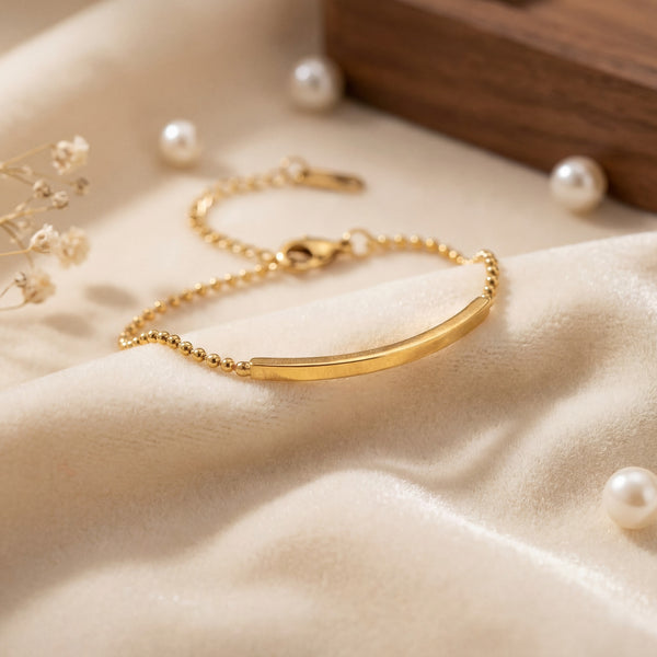 Close-up of Anti-Tarnish Gold Plated Celeste Bar Bracelet showing gold bar detail on satin fabric with pearls