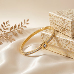 Gold bracelet with diamond on a decorative box and fabric background