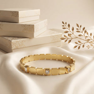 Gold bracelet with diamond accents on a soft beige background