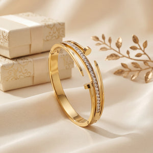 Gold bracelet with diamond accents on a soft beige background