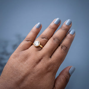 Woman wearing Round Halo CZ Solitaire Ring in gold plated finish with sparkling white stone by House of Viya